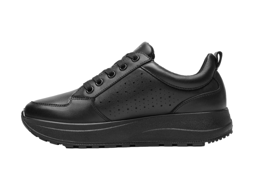 Tenis Flexi color negro de cuero con detalles perforados y suela gruesa.