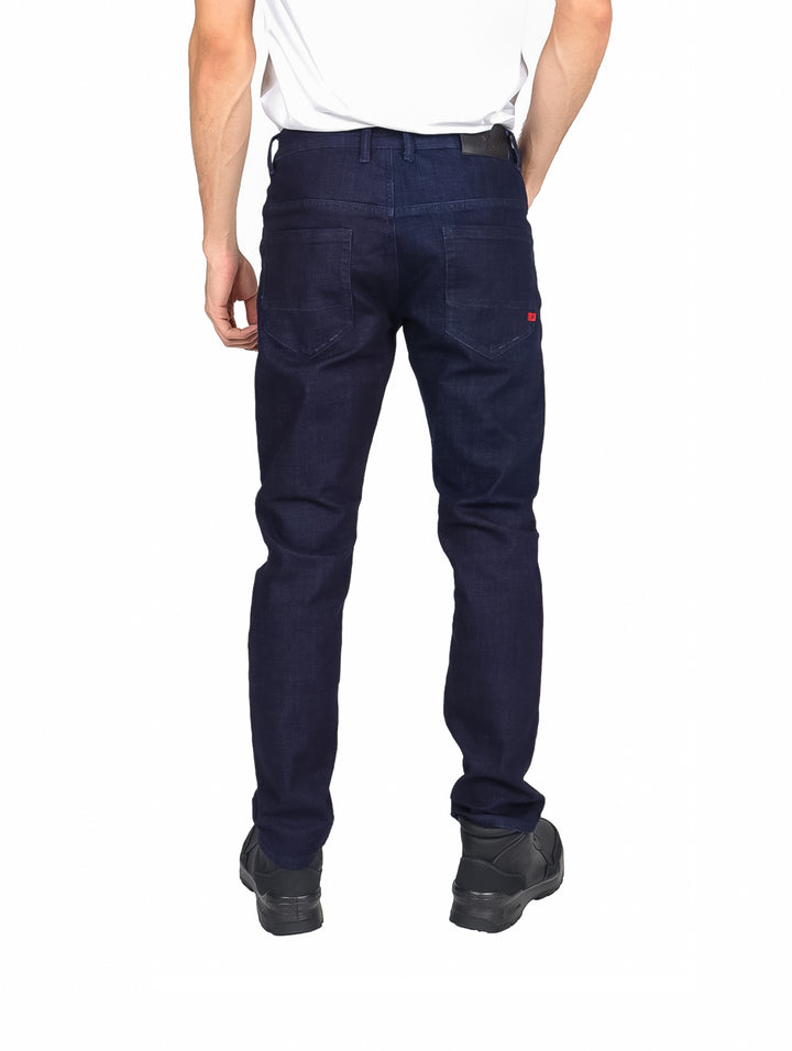 Hombre vistiendo pantalones jeans color azul marino de corte recto y calzado negro sobre fondo blanco.