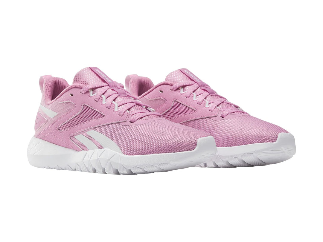 Tenis deportivos Reebok Flexagon Energy TR 4 en color rosa con suela blanca y detalles sintéticos.