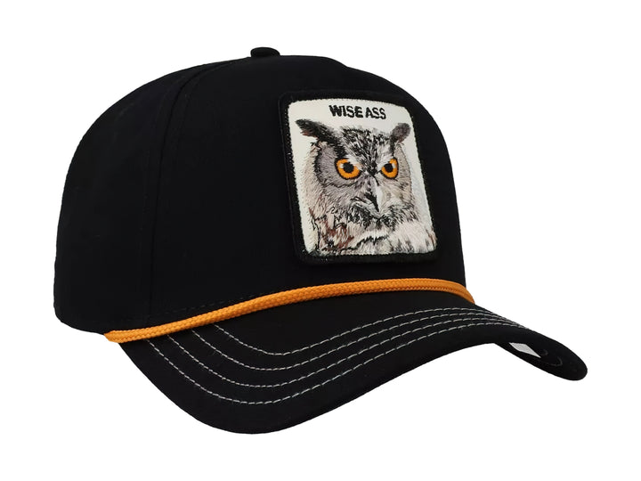 Gorra negra Goorin Bros con parche frontal de un búho y detalle de cordón naranja sobre la visera.