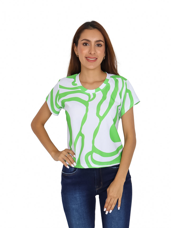 Mujer vistiendo blusa blanca con estampado abstracto verde y jeans azules.