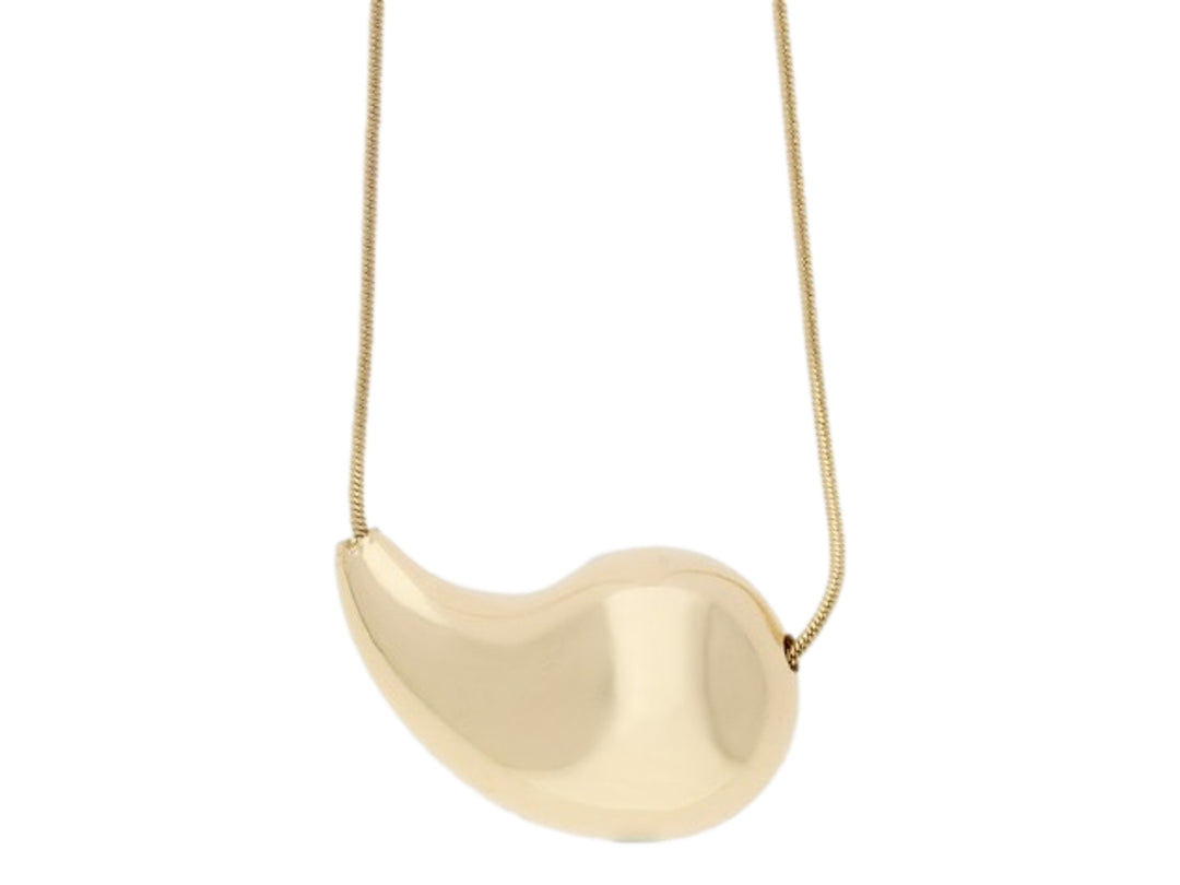 Collar de color dorado con un dije grande de forma orgánica y superficie brillante.