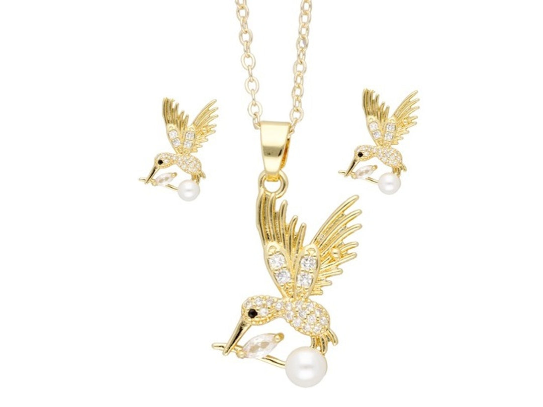 Set de collar y aretes dorados con diseño de colibrí adornado con cristales y una perla blanca.