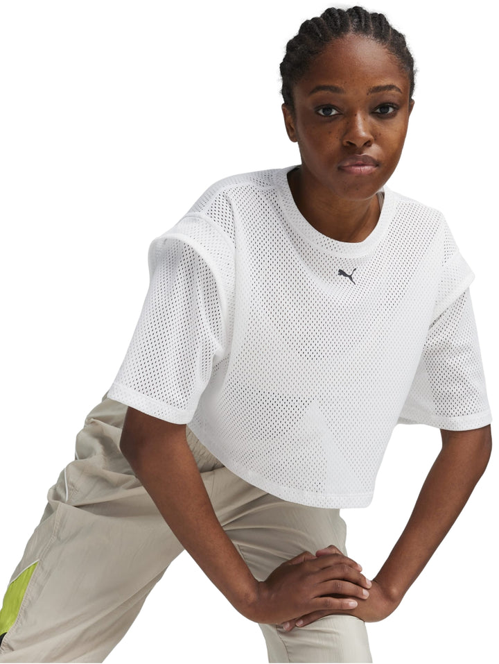 Mujer vistiendo una camiseta crop top blanca de malla de la marca PUMA.
