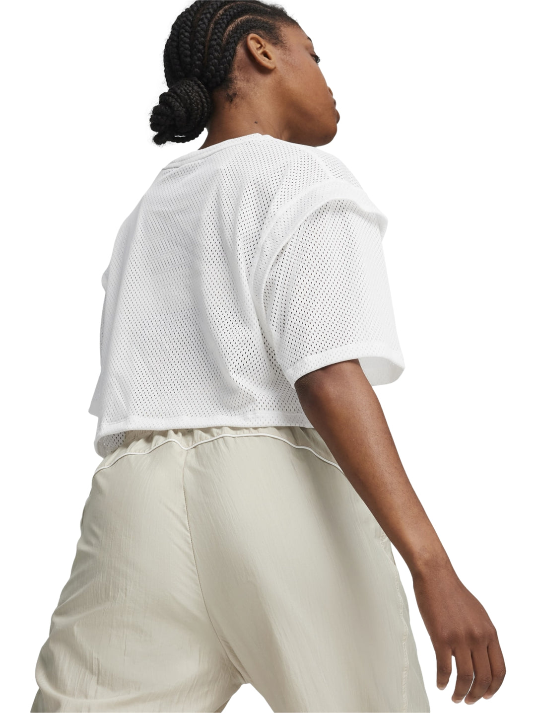 Mujer vistiendo una camiseta crop top blanca de malla de la marca PUMA.