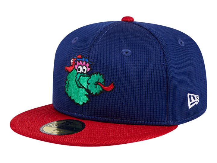 Gorra New Era azul con visera roja y un personaje verde bordado en el frente.