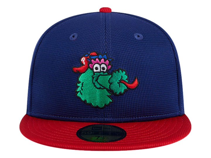 Gorra New Era azul con visera roja y un personaje verde bordado en el frente.