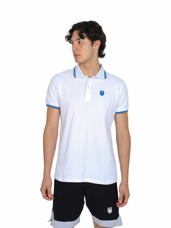 Hombre vistiendo playera polo blanca de manga corta con detalles azules en el cuello y los bordes de las mangas.