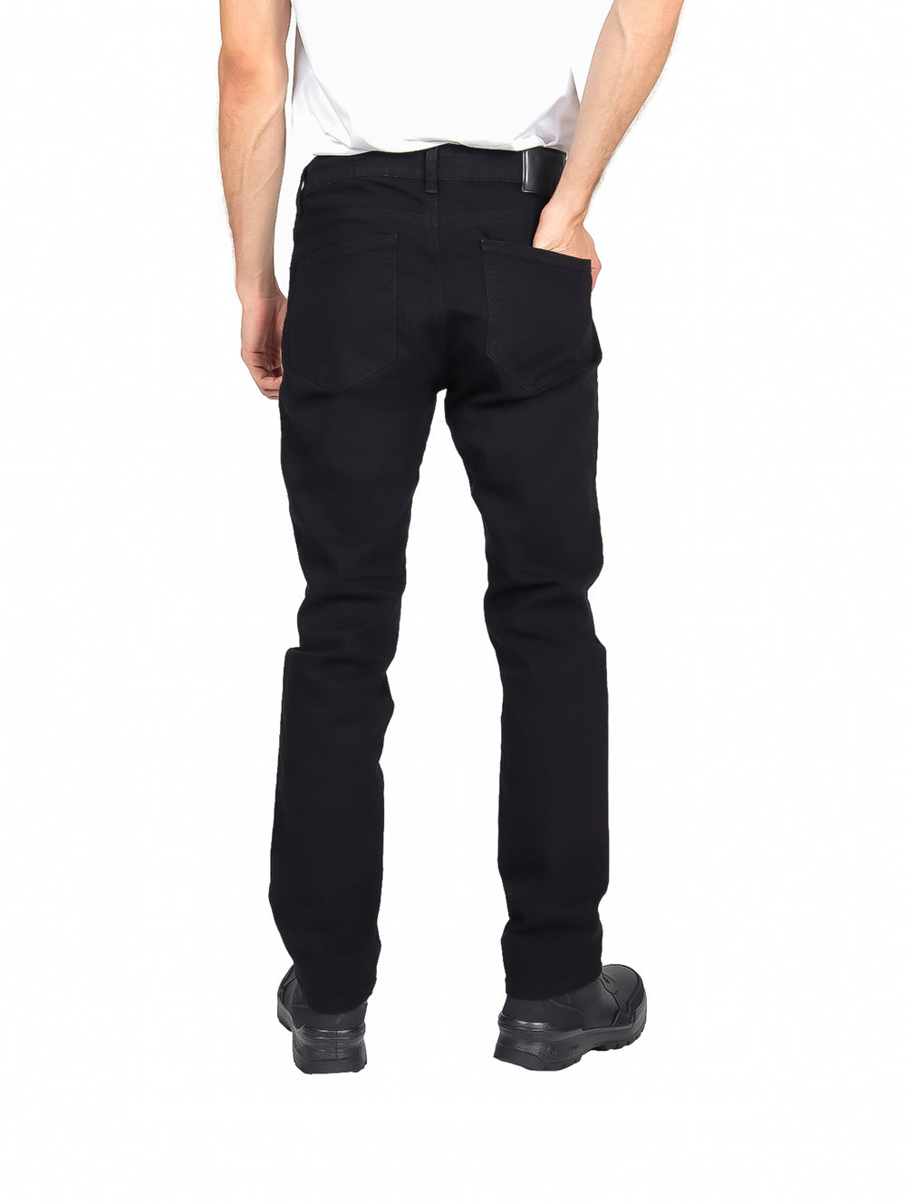 Hombre vistiendo pantalones jeans slim fit de color negro y calzado negro sobre fondo blanco.