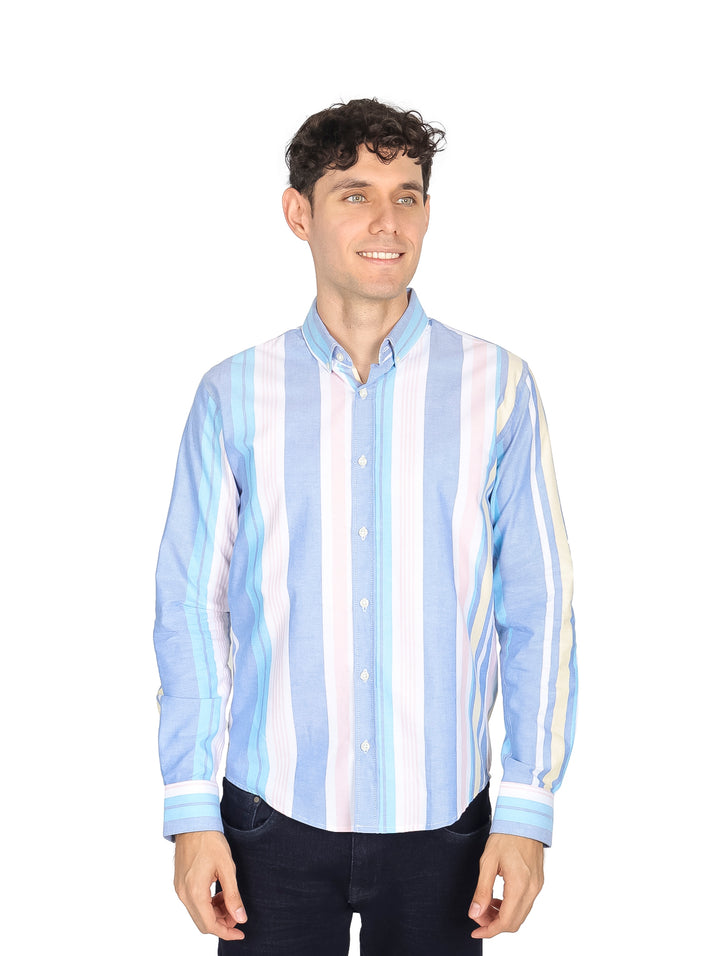 Hombre vistiendo camisa de manga larga con rayas verticales en tonos azul, blanco, amarillo y rosa.