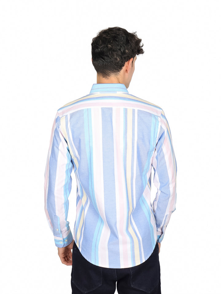 Hombre vistiendo camisa de manga larga con rayas verticales en tonos azul, blanco, amarillo y rosa.