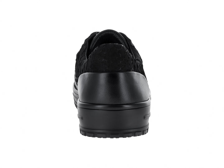 Tenis casuales color negro con textura de piel de pitón y detalles en nobuck, suela plana negra.