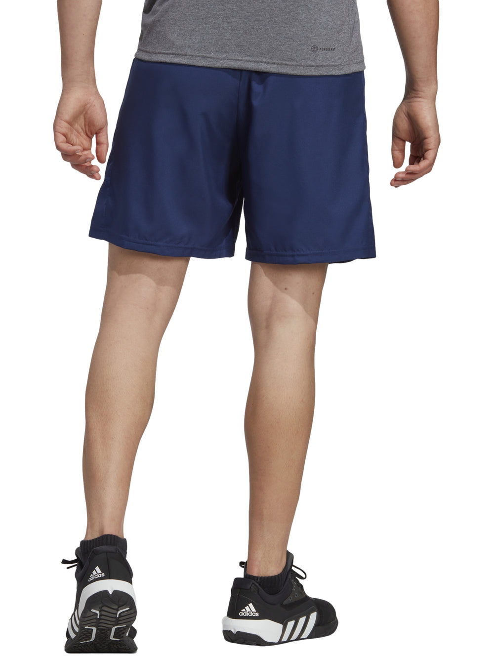 Hombre vistiendo shorts deportivos Adidas en color azul oscuro.