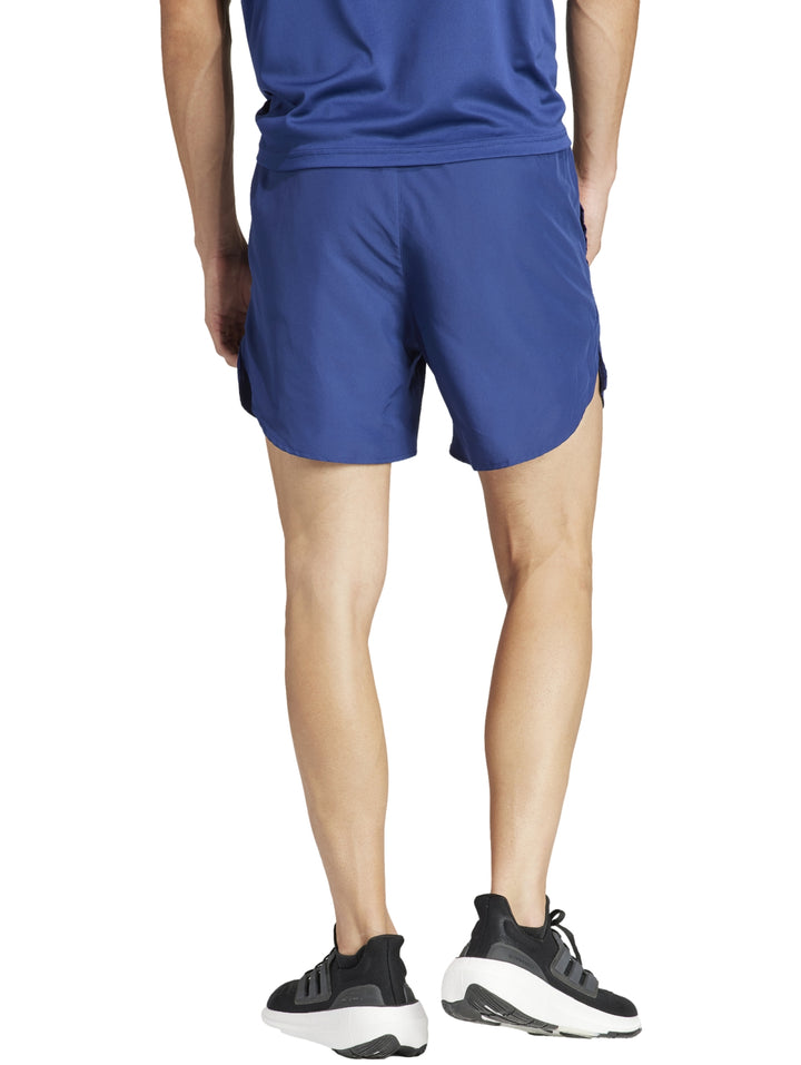 Hombre vistiendo shorts deportivos Adidas en color azul oscuro para correr.