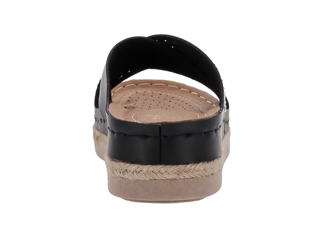 Sandalia negra de plataforma con correa decorada con tachuelas y suela de esparto beige.