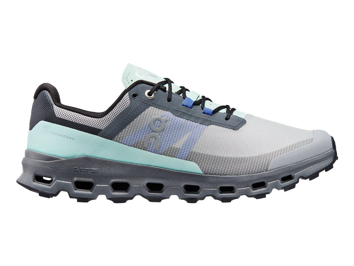 Tenis deportivos On Cloud color gris con detalles en azul claro y suela gruesa texturizada.