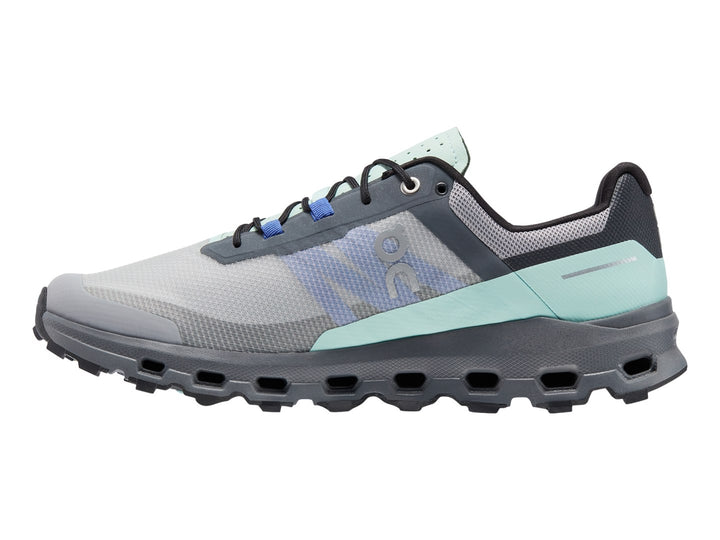 Tenis deportivos On Cloud color gris con detalles en azul claro y suela gruesa texturizada.