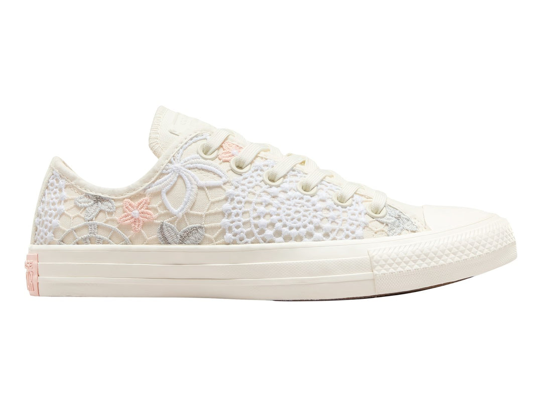 Tenis Converse Chuck Taylor All Star color blanco con detalles de encaje, bordados de mariposas y flores en tonos durazno.