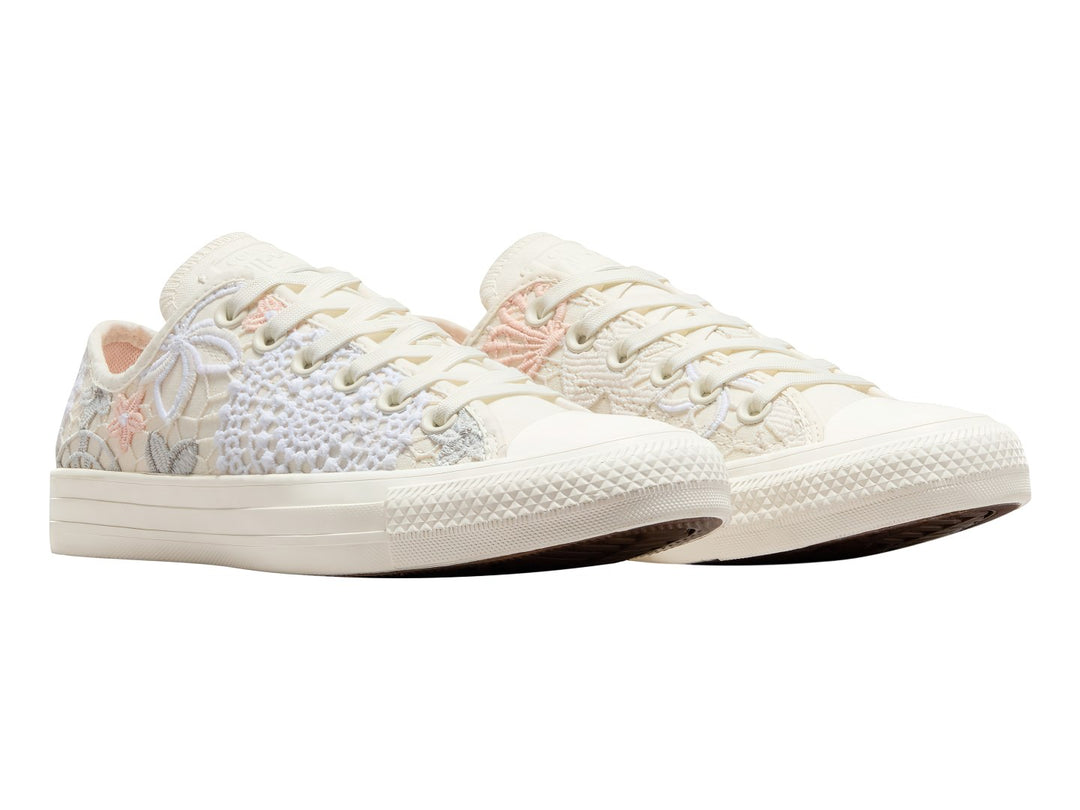 Tenis Converse Chuck Taylor All Star color blanco con detalles de encaje, bordados de mariposas y flores en tonos durazno.