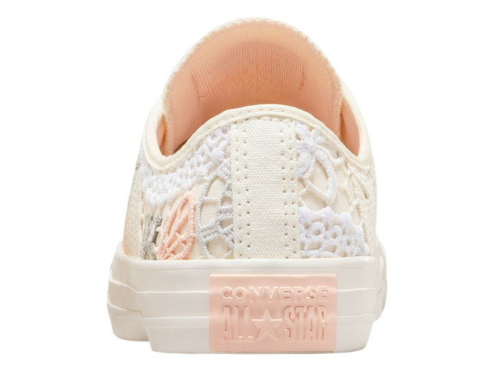 Tenis Converse Chuck Taylor All Star color blanco con detalles de encaje, bordados de mariposas y flores en tonos durazno.