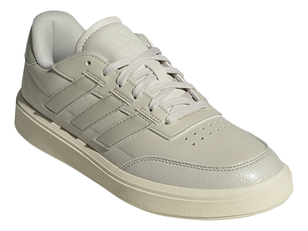 Tenis Adidas Courtblock color gris claro con franjas laterales y suela blanca.