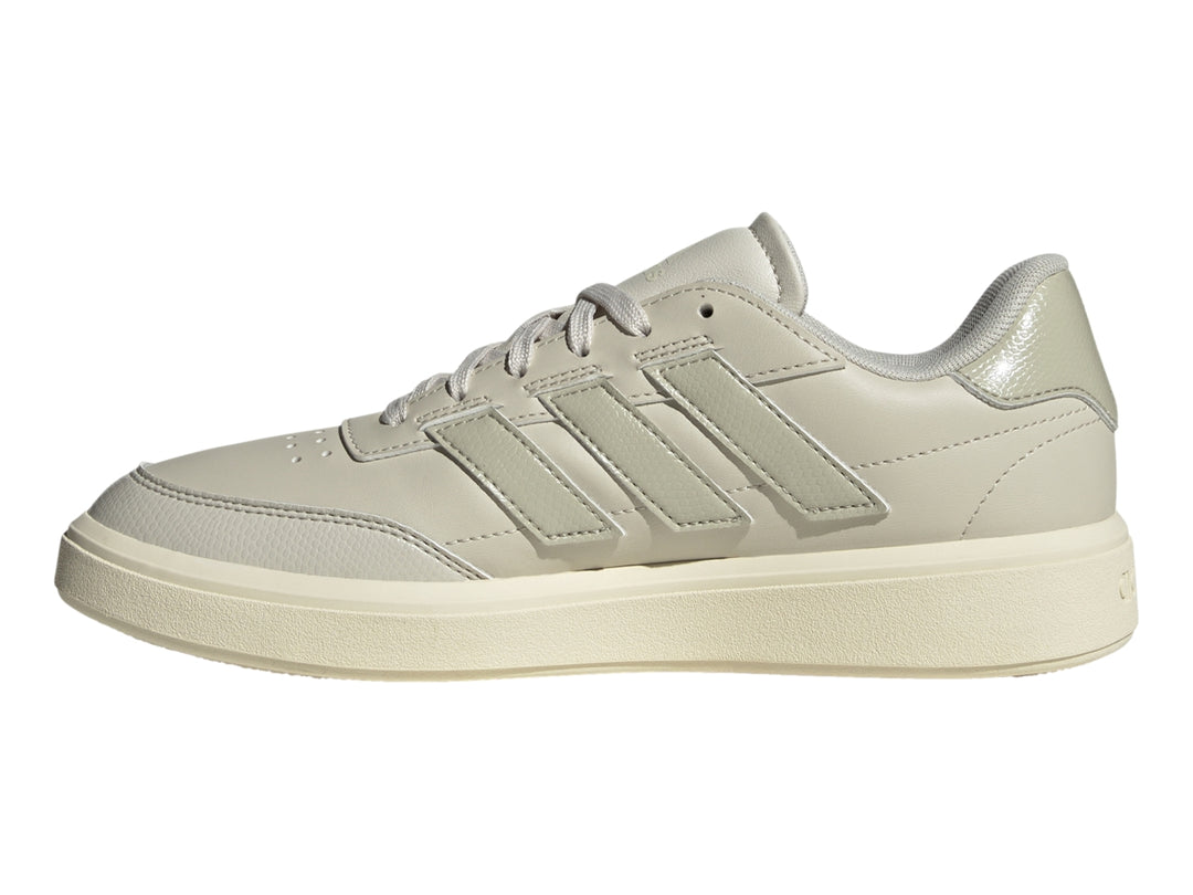 Tenis Adidas Courtblock color gris claro con franjas laterales y suela blanca.