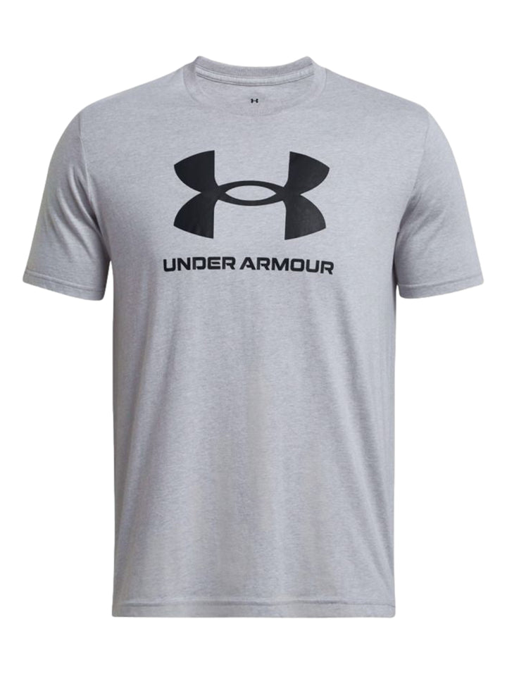 Hombre vistiendo una playera deportiva de color gris con el logotipo de Under Armour en negro en el pecho.