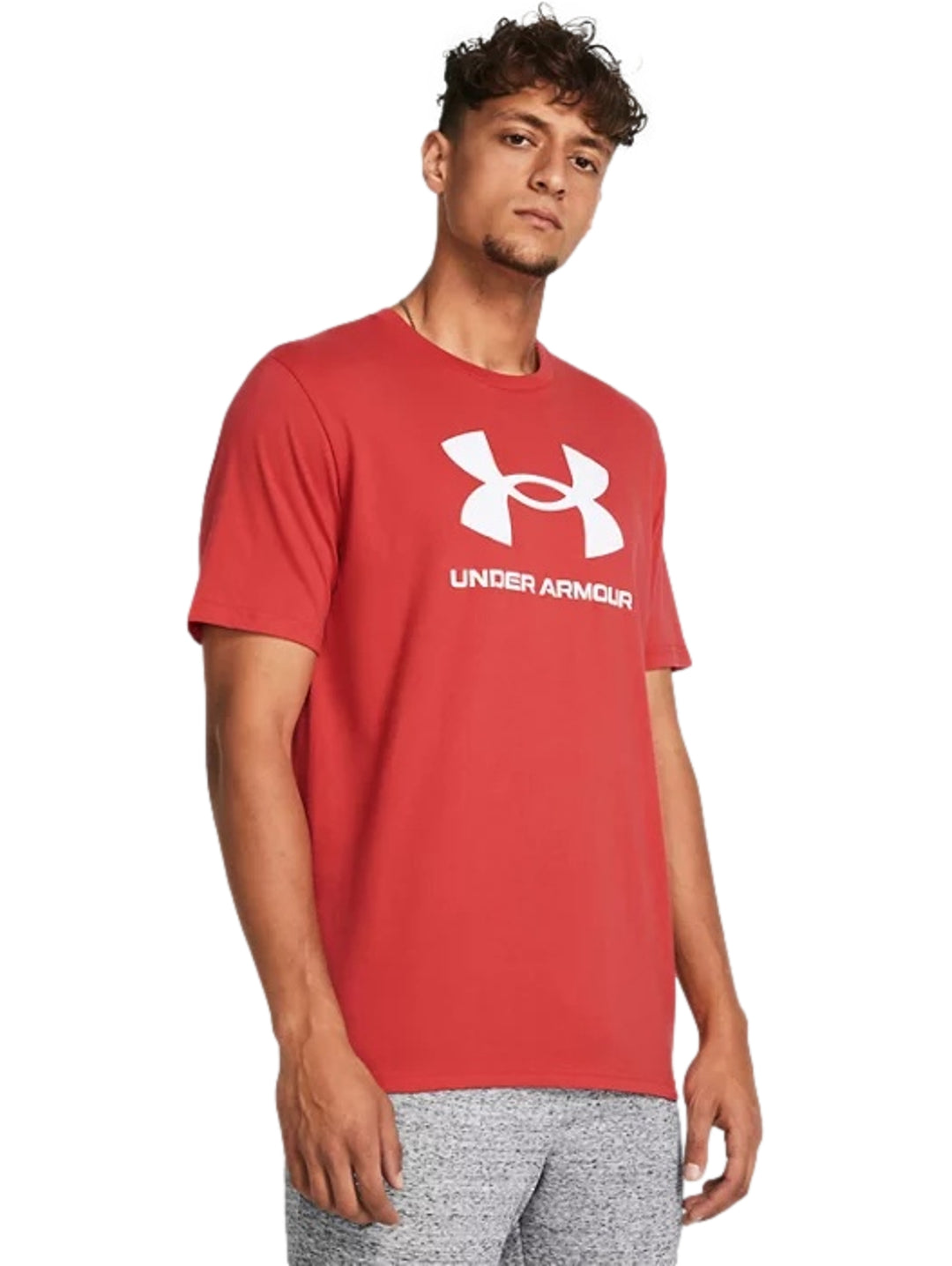 Hombre vistiendo una playera deportiva Under Armour de color rojo con logotipo blanco en el pecho.