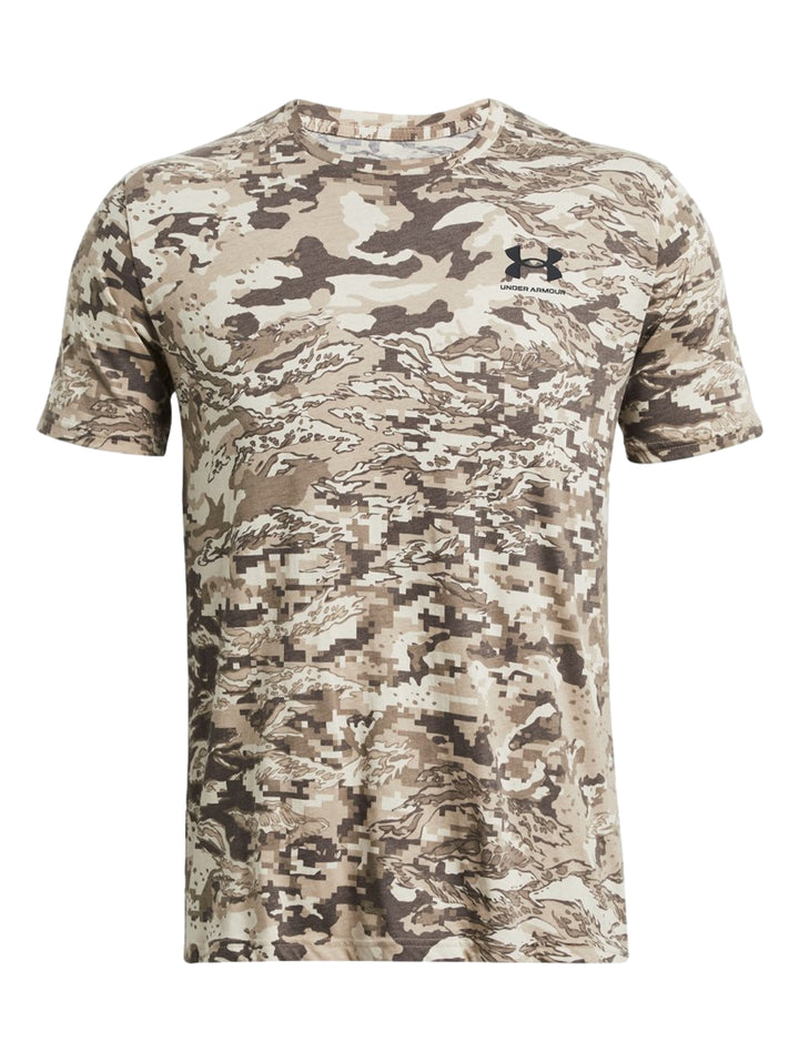 Hombre vistiendo camiseta Under Armour de manga corta con estampado de camuflaje en tonos marrón y beige.