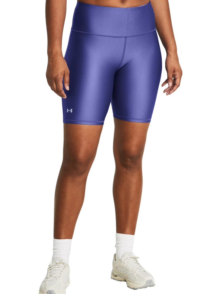 Mujer vistiendo mallas deportivas cortas Under Armour en color morado brillante con cintura alta.