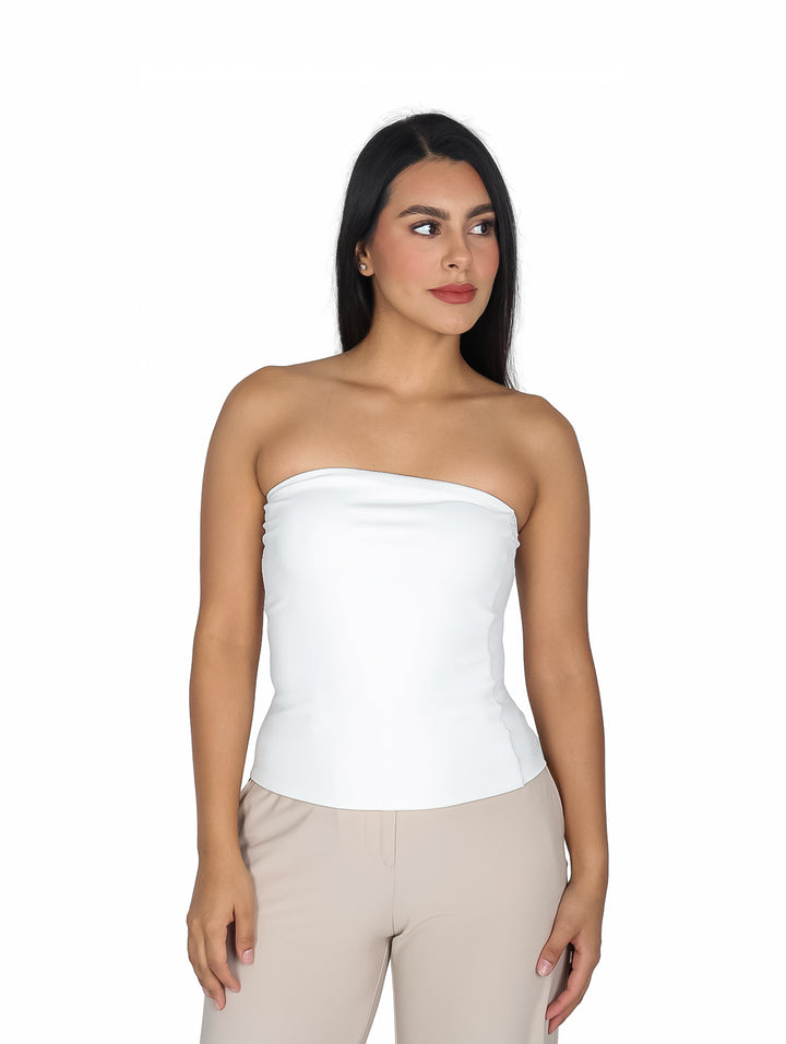 Mujer modelando una blusa strapless blanca ajustada al cuerpo.