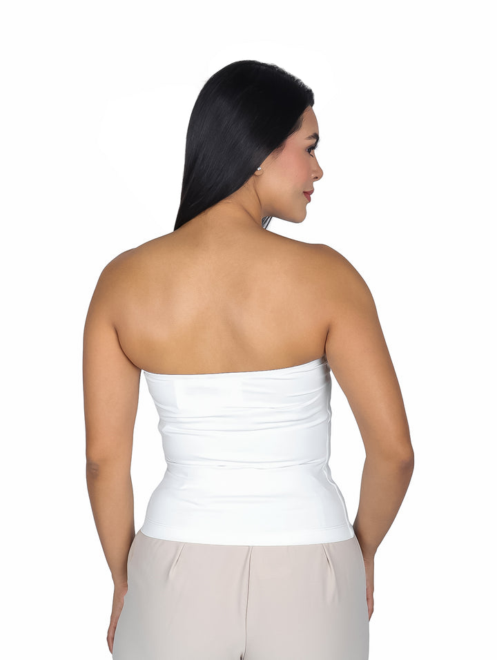 Mujer modelando una blusa strapless blanca ajustada al cuerpo.