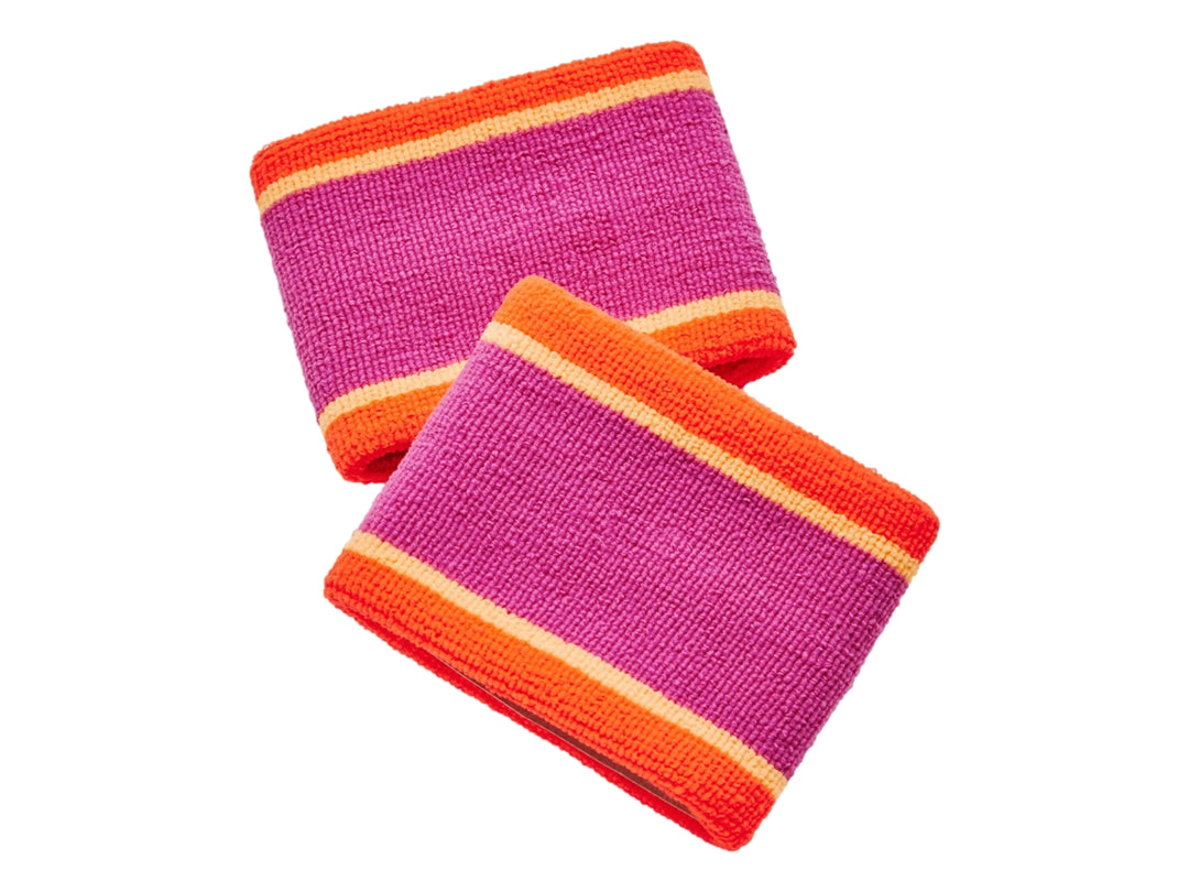 Par de muñequeras deportivas Under Armour en colores rosa y naranja con logo negro central.
