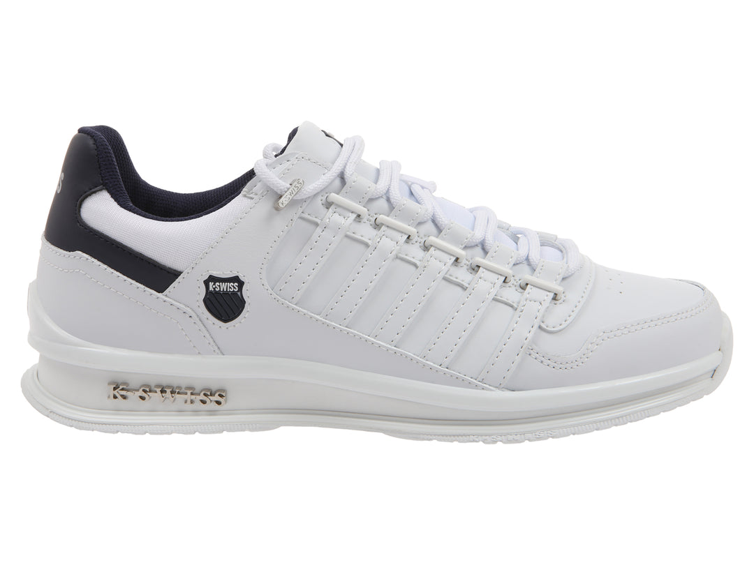 Tenis deportivos K-Swiss color blanco con detalles en azul marino en el talón y suela blanca.