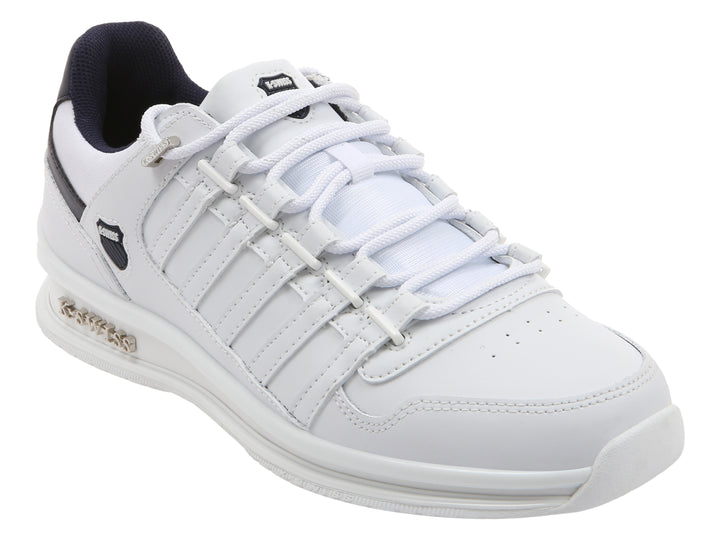 Tenis deportivos K-Swiss color blanco con detalles en azul marino en el talón y suela blanca.