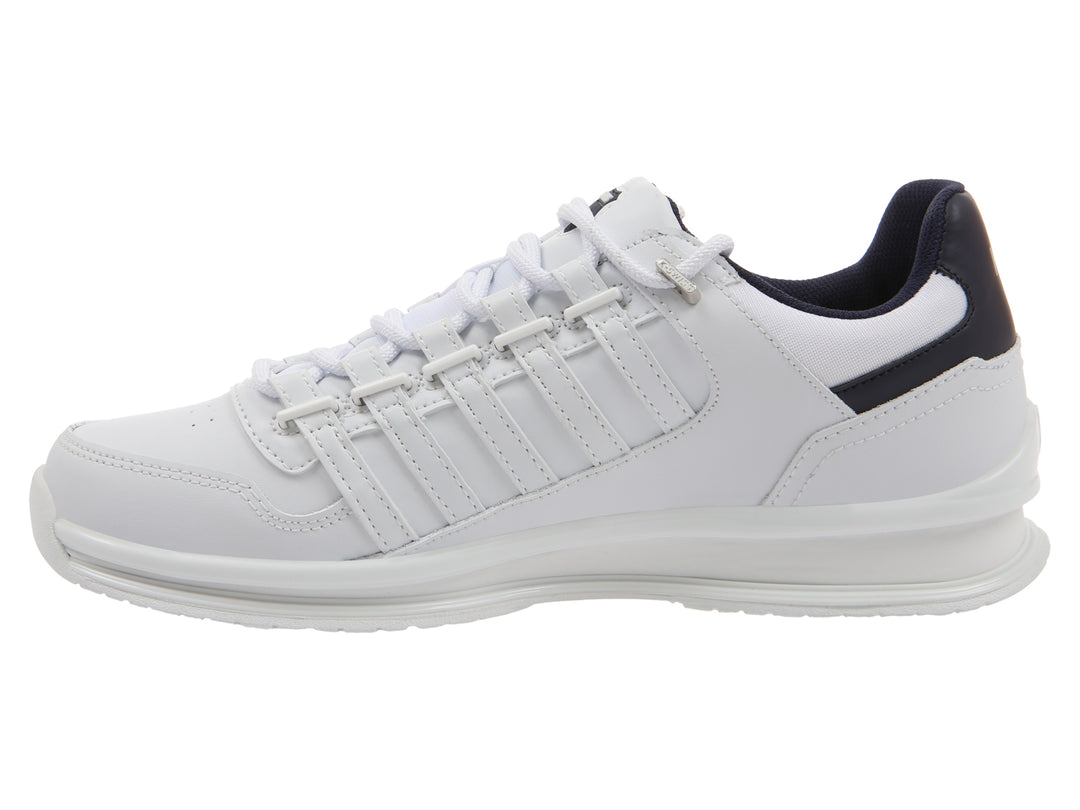 Tenis deportivos K-Swiss color blanco con detalles en azul marino en el talón y suela blanca.