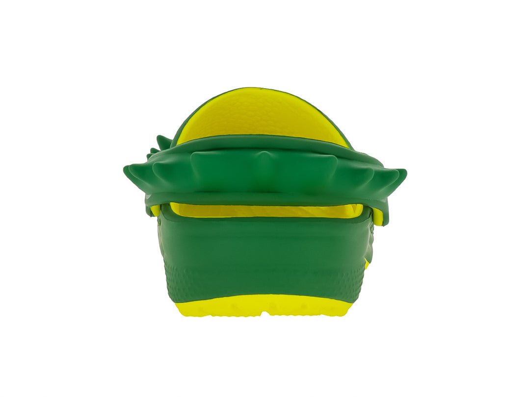 Zueco Crocs verde con suela amarilla y detalles de picos en la parte superior.