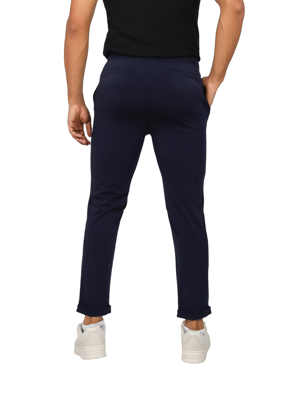 Hombre vistiendo pantalones jogger color azul marino de corte ajustado y calzado blanco.