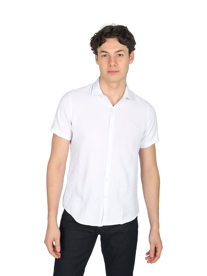 Hombre vistiendo una camisa blanca de manga corta y cuello con pantalones negros.