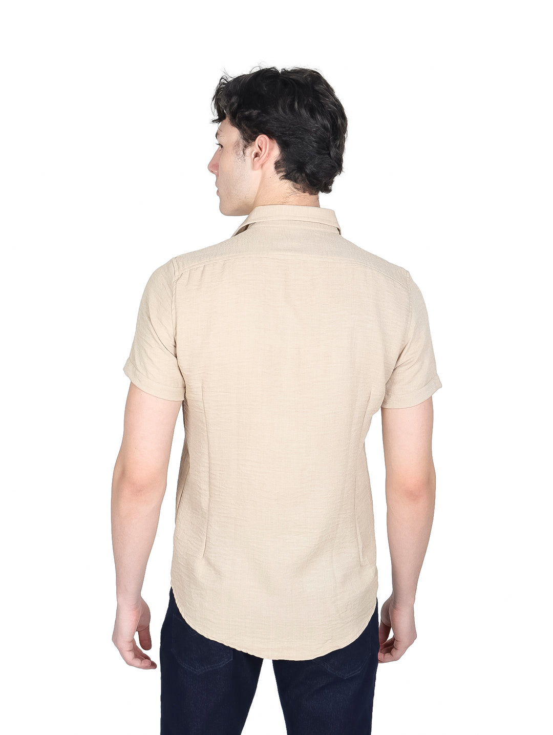 Hombre vistiendo camisa de manga corta color beige con botones y pantalones azul marino.