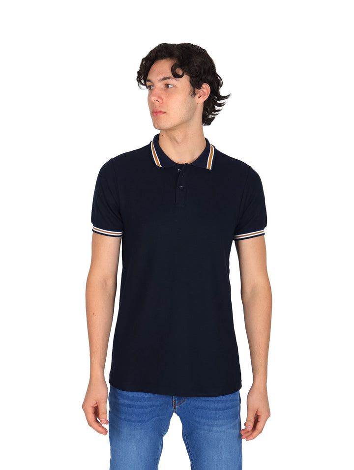 Hombre vistiendo playera polo color marino con detalles de rayas blancas y beige en el cuello y mangas.