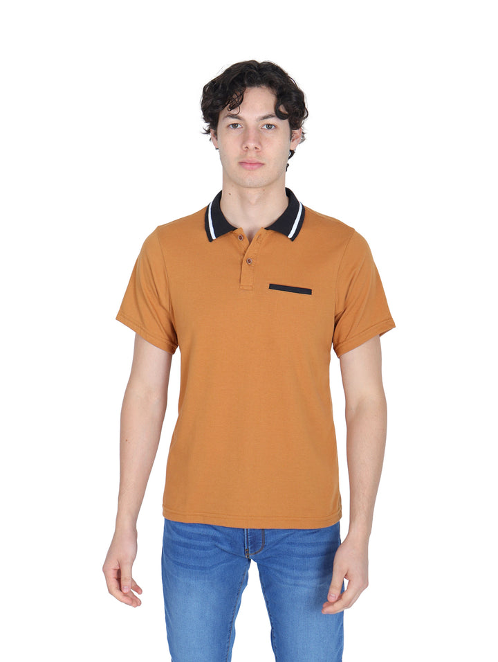 Hombre vistiendo playera polo color ocre con cuello negro y pantalones azules.