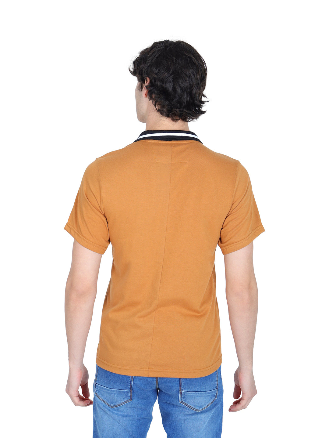 Hombre vistiendo playera polo color ocre con cuello negro y pantalones azules.