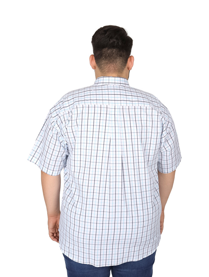 Hombre vistiendo camisa blanca de manga corta con estampado de cuadros azules y negros.