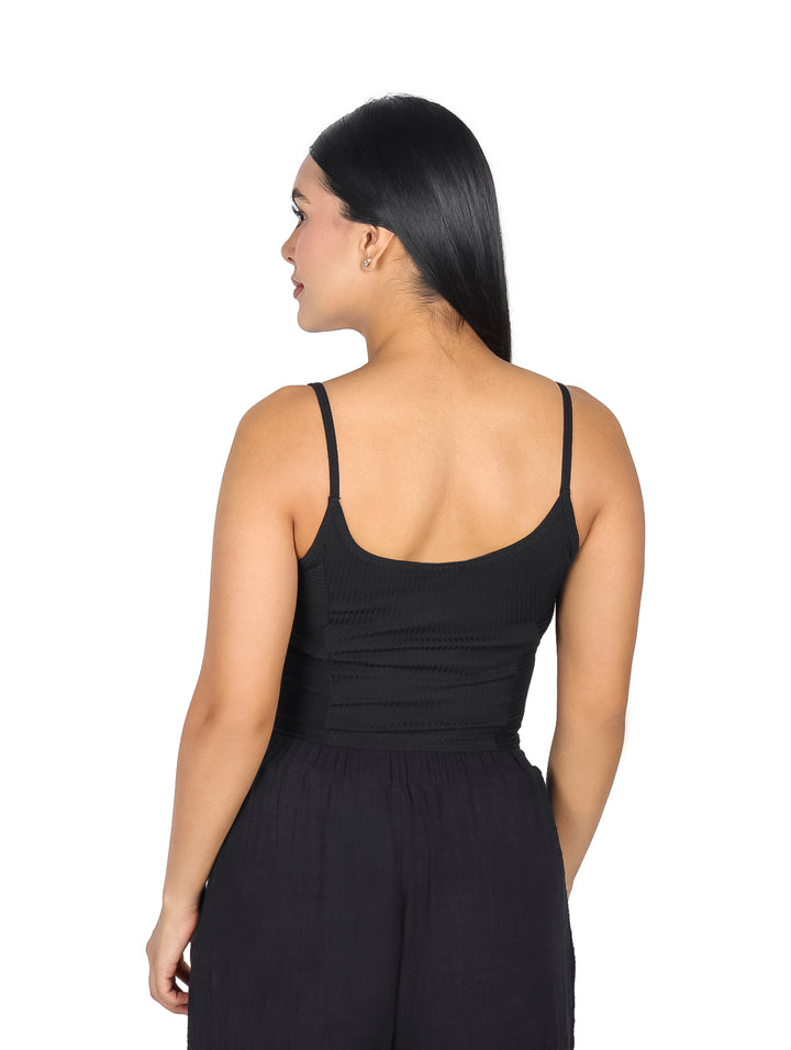 Mujer vistiendo una blusa crop top negra sin mangas de la marca ATOK.
