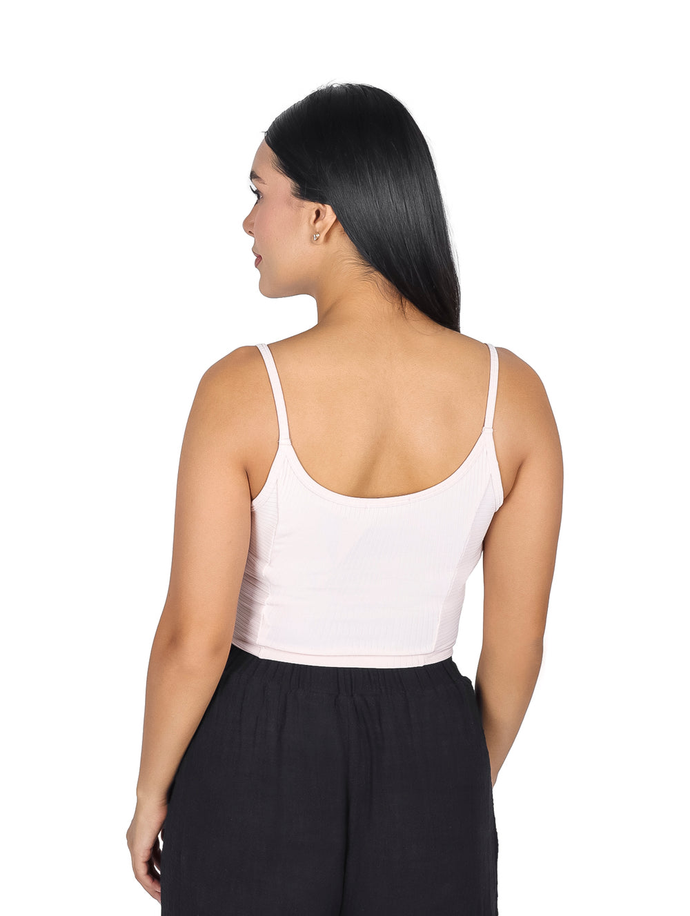 Mujer vistiendo una blusa rosa sin mangas ajustada y pantalones negros.