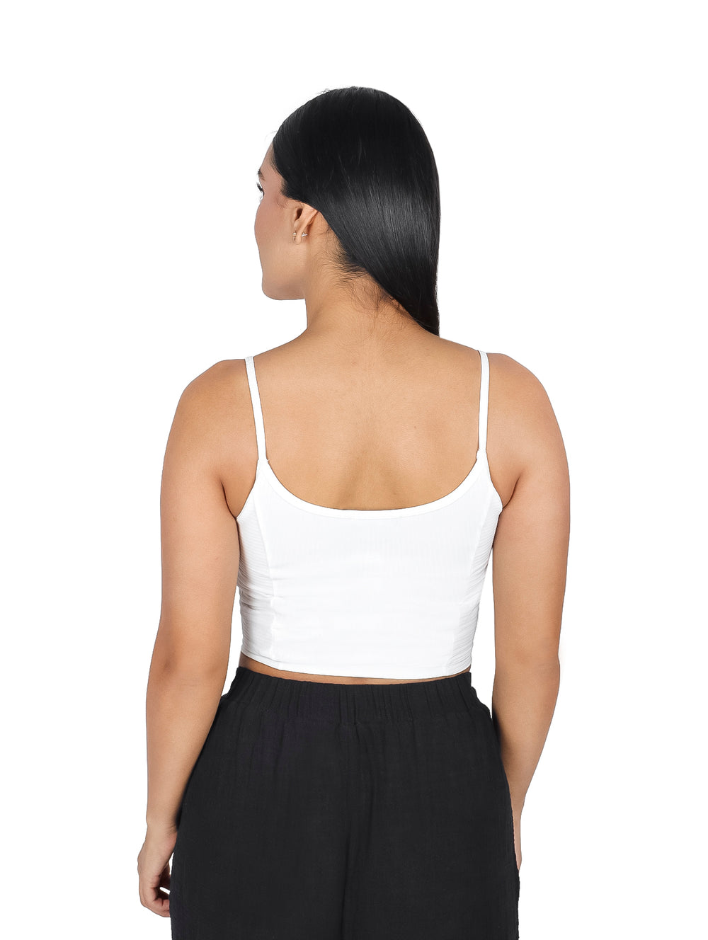 Mujer modelando una blusa blanca sin mangas tipo crop top con pantalones negros.