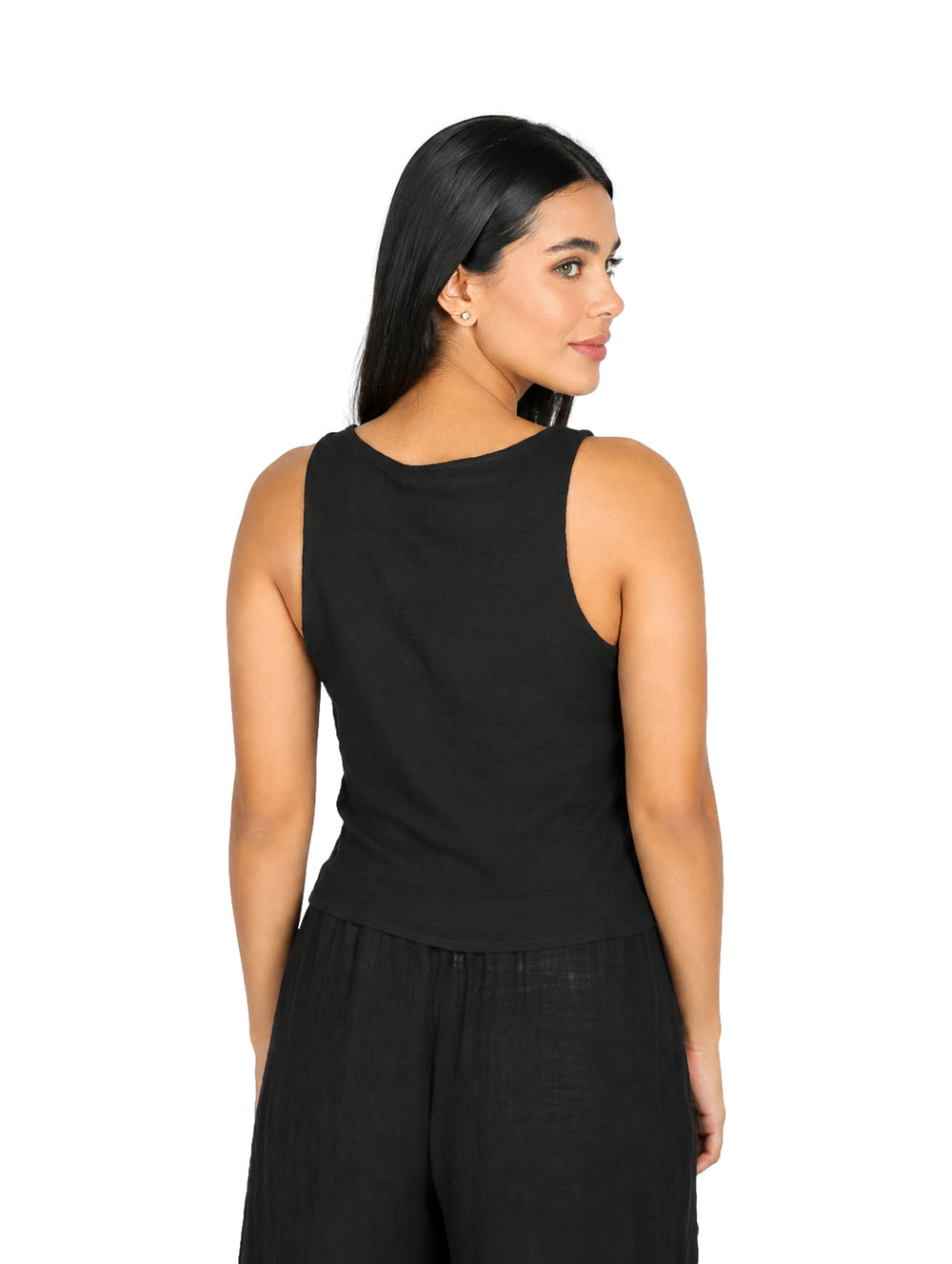 Mujer vistiendo blusa negra sin mangas con detalle de lazo frontal.
