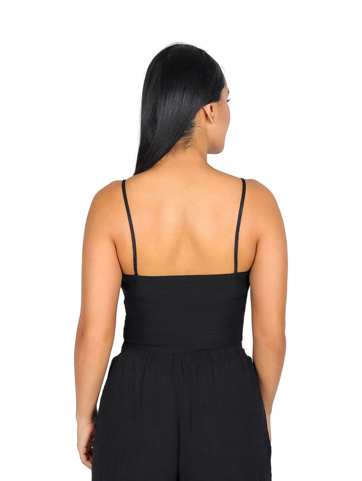 Blusa negra de tirantes con un moño grande satinado en la parte frontal.