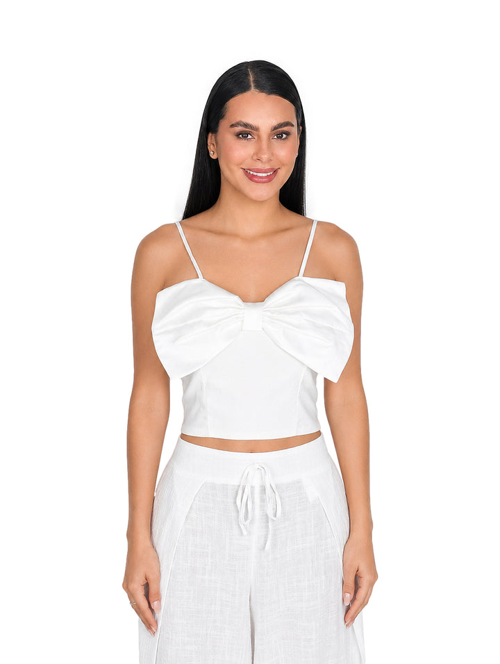Blusa blanca corta con un moño grande en el frente y tirantes delgados.